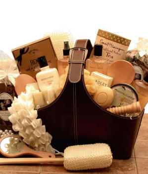 Luxury spa gift basket with bath products, gourmet tea, chocolates, a loofah, and wooden spa tools.