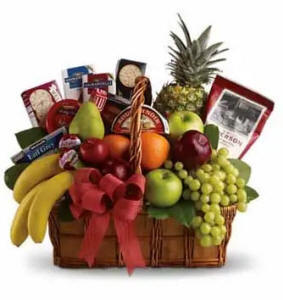 A variety of fresh fruit and gourmet foods in a beautiful gift basket